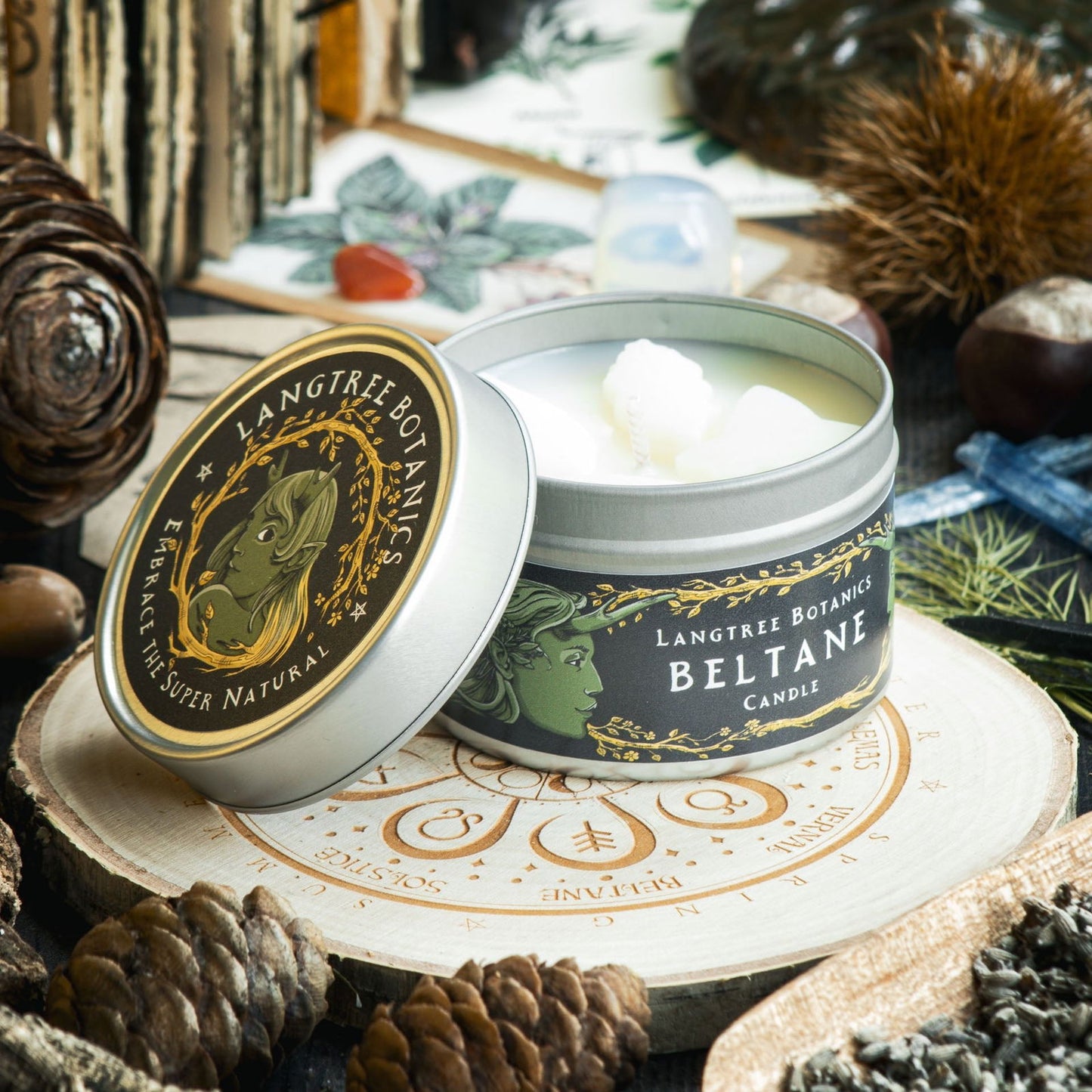 Tin with a lid to one side reveals small wax leaves embedded into the Beltane rapeseed wax candle from Langtree Botanics