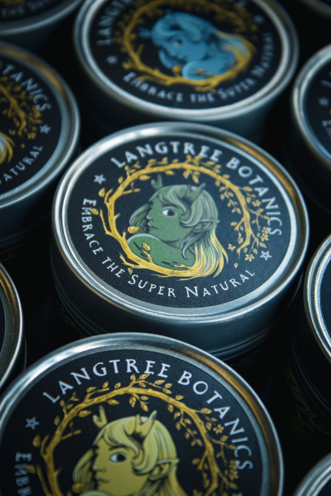 Looking down onto a row of candle tins featuring the Langtree Botanics logo