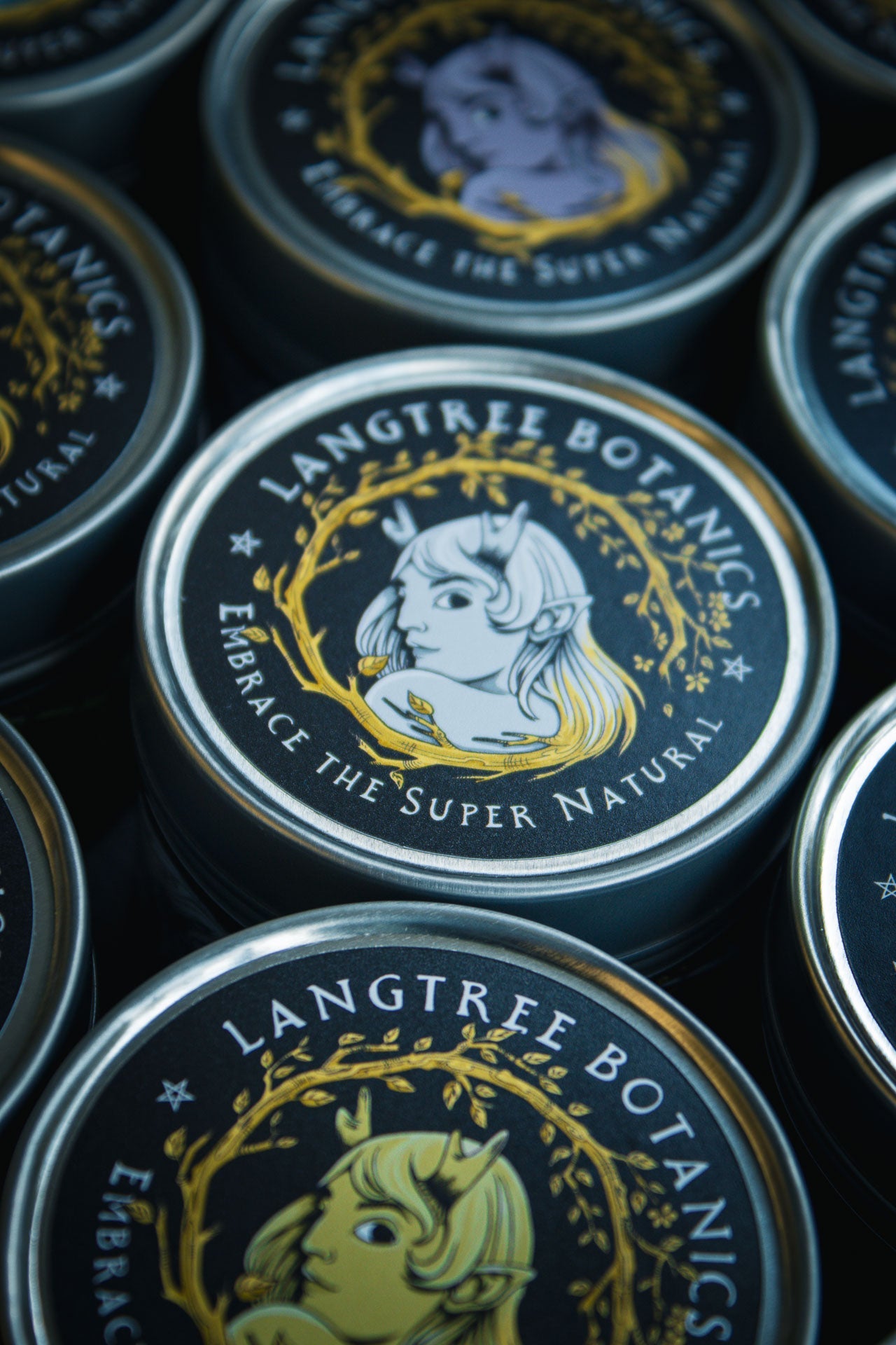 Looking down onto a row of candle tins featuring the Langtree Botanics logo