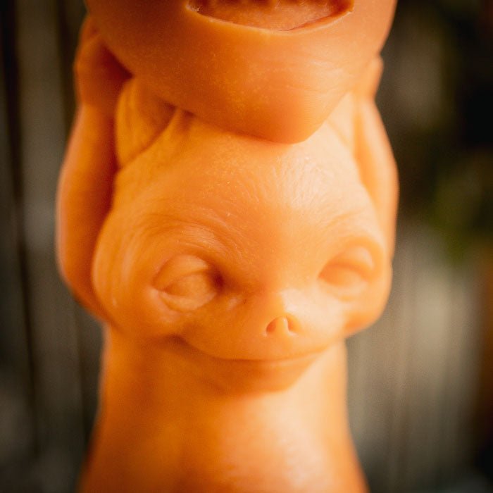 Closeup of an orange mythical creature holding a jack-o-lantern turnip above it's head