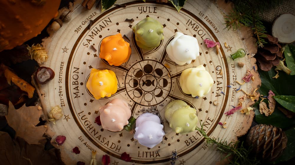 8 Langtree Botanics nature Sprite candles sit on top of a wooden wheel-of-the-year decorative log slice