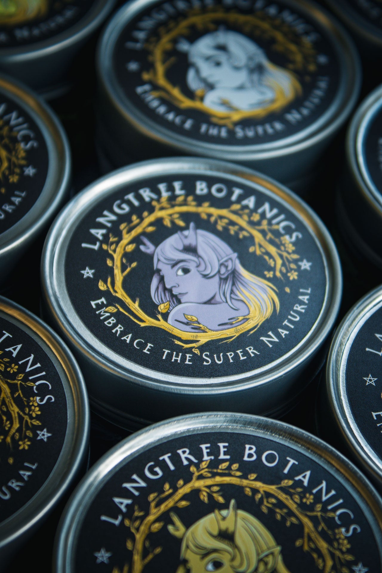 Looking down onto a row of candle tins featuring the Langtree Botanics logo