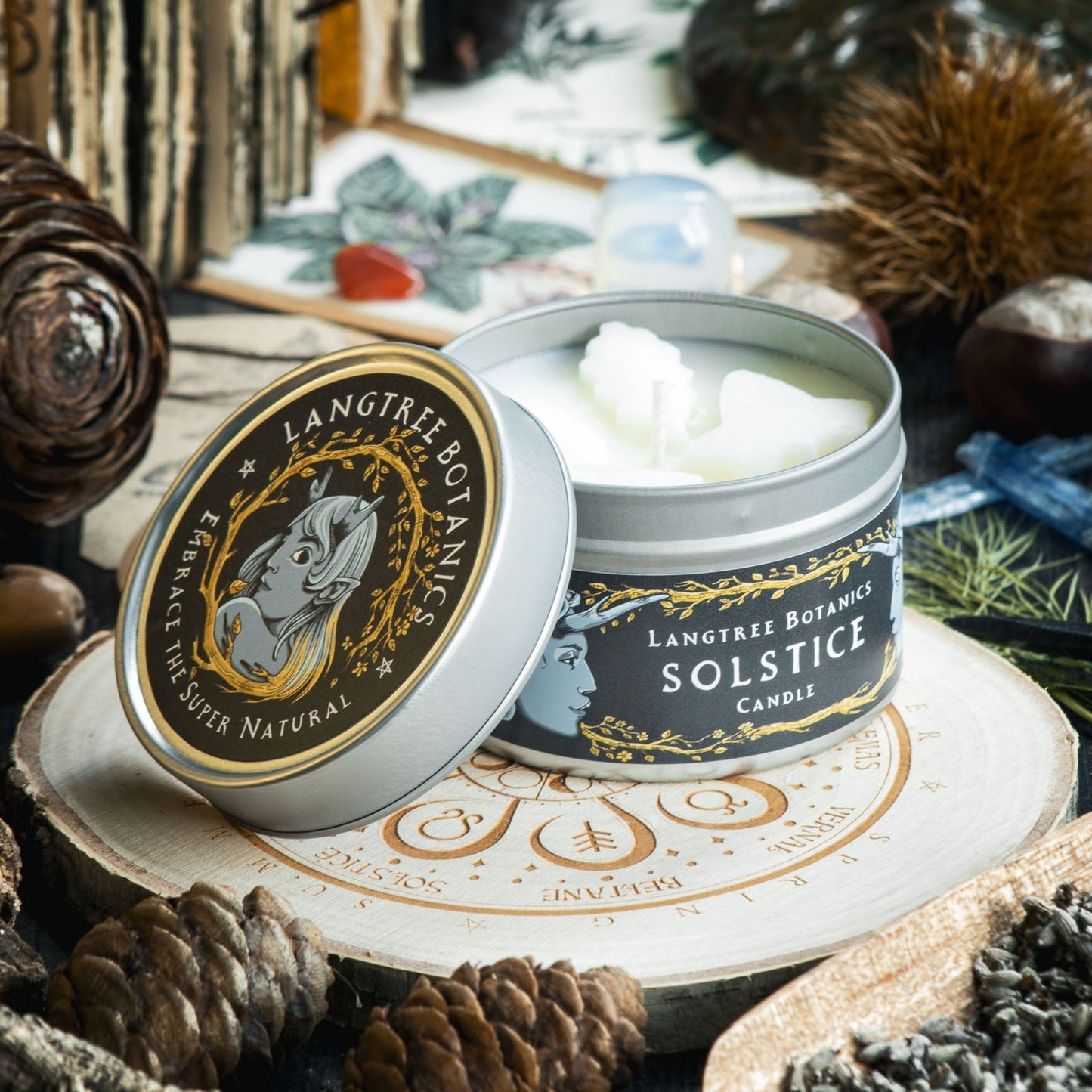 Tin with a lid to one side reveals small wax leaves embedded into the Solstice rapeseed wax candle from Langtree Botanics