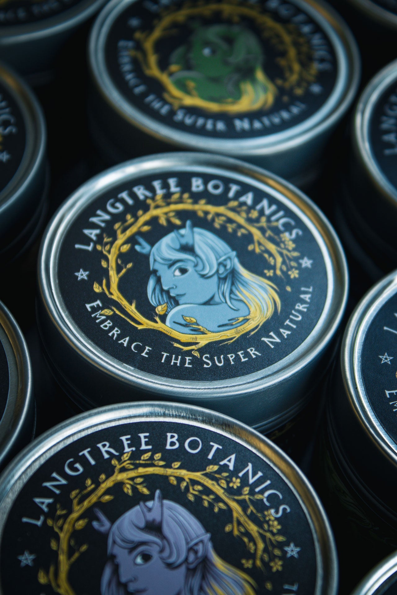 Looking down onto a row of candle tins featuring the Langtree Botanics logo
