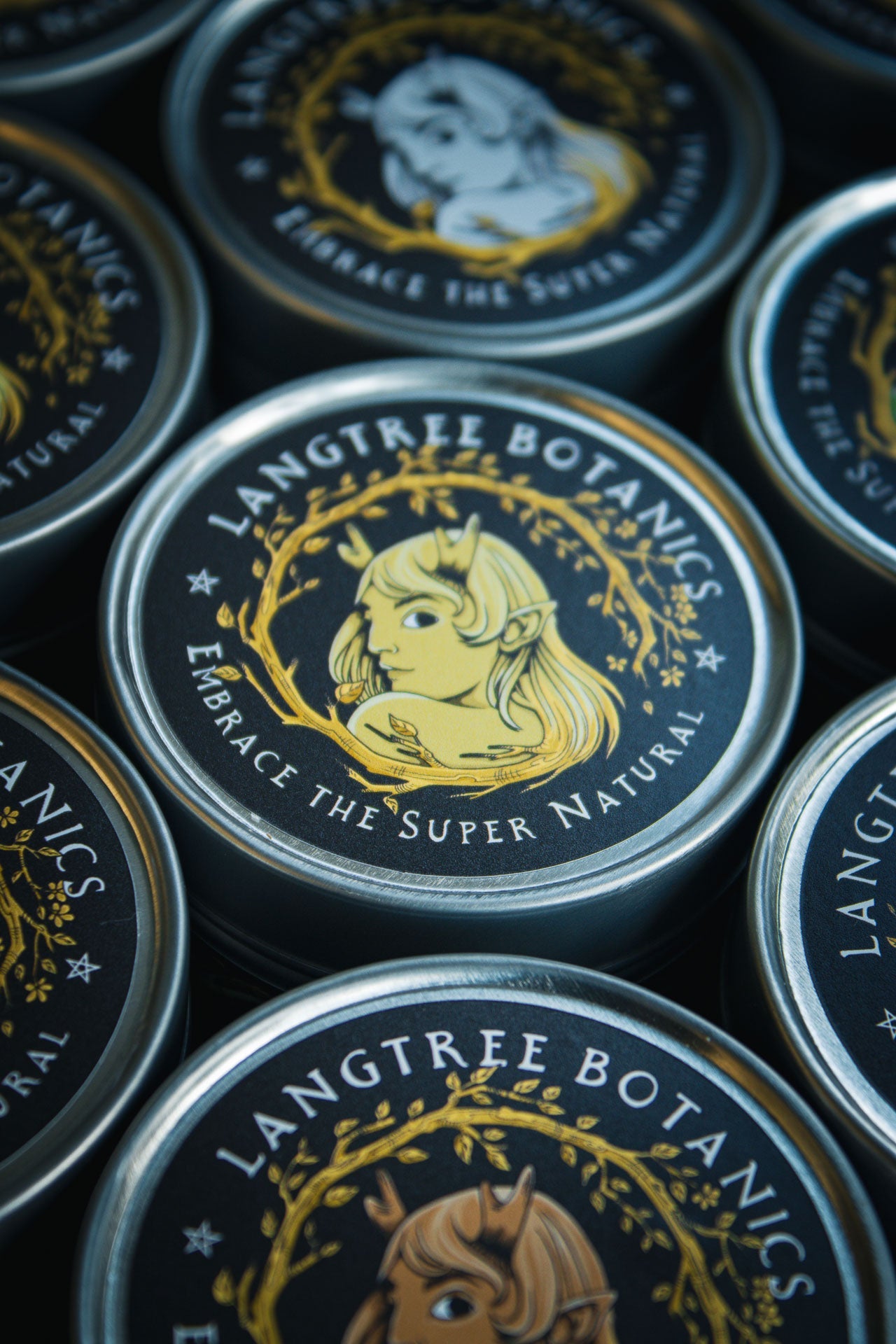 Looking down onto a row of candle tins featuring the Langtree Botanics logo