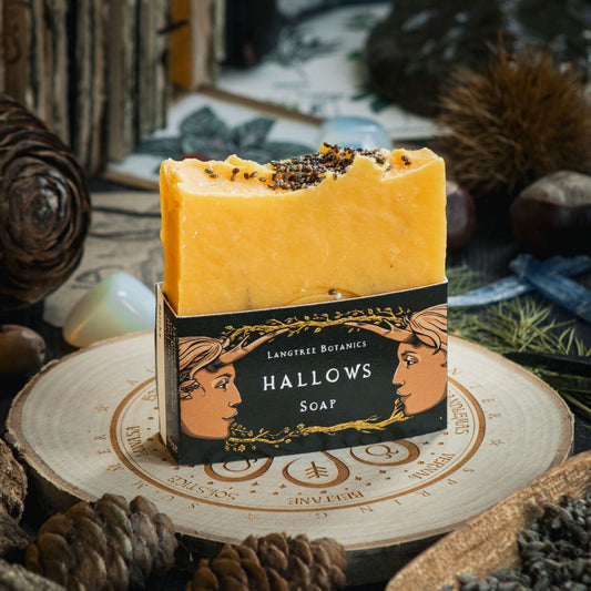 Langtree Botanics bright orange Hallows soap on a decorative log slice surrounded by seasonal foliage celebrating Halloween