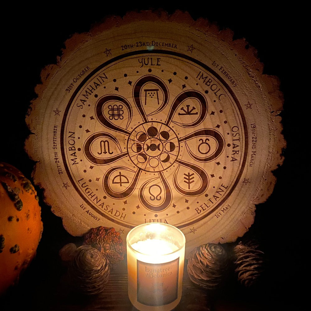 Seasonal Celebration Wheel of the Year Decorative Wooden Slice lit by candlelight