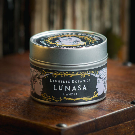 Aluminium tin candle with its lid on sits atop an antique wooden box displaying the Langtree Botanics fragrance, Lunasa