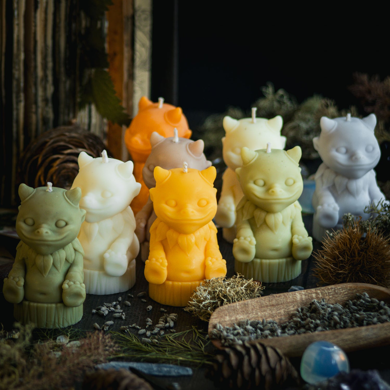 A collection of brightly coloured rapeseed wax candles in the shape of cute mythical woodland creatures