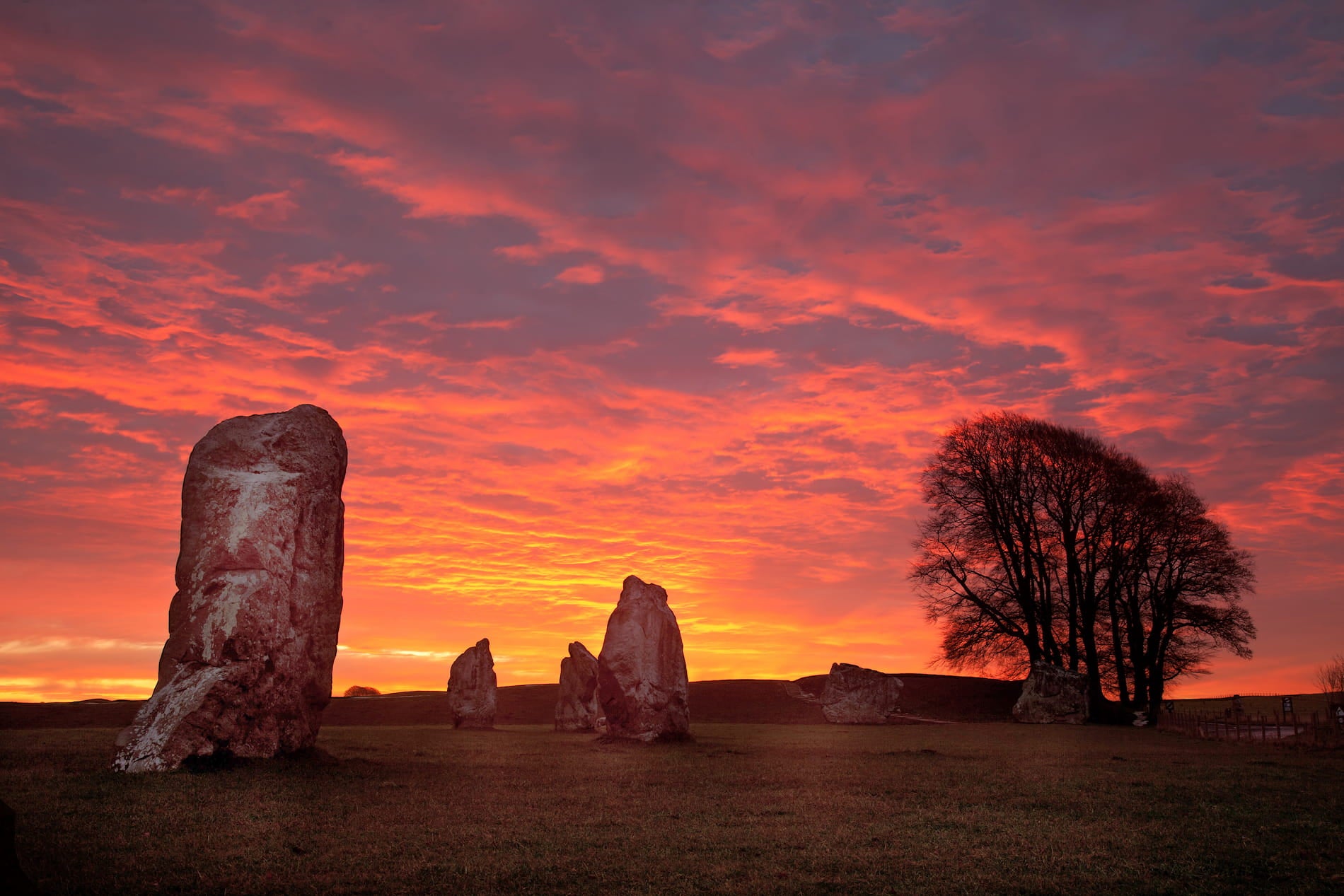 A breathtaking sunrise over a mystical stone circle, shrouded in ancient secrets and natural beauty.