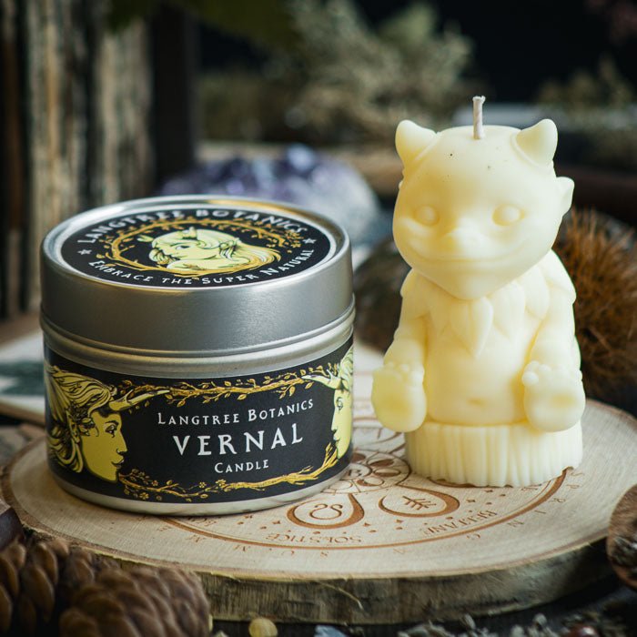 A metal tin container candle sat next to a pastel yellow woodland creature rapeseed wax candle