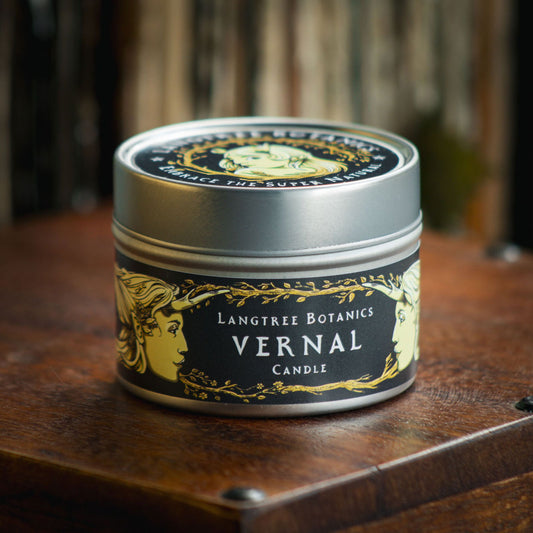 Aluminium tin candle with its lid on sits atop an antique wooden box displaying the Langtree Botanics fragrance, Vernal